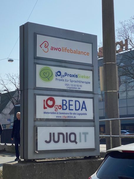Standort-Schild mit fünf Firmenlogos, Logobeda, LogoPraxis Sieker.